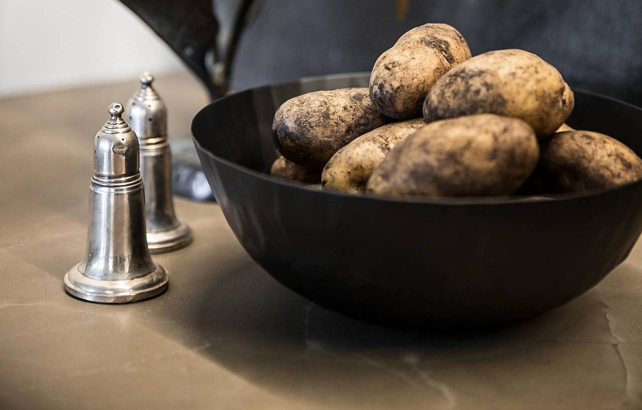 Salt and pepper shakers and a bowl of potatoes on a SieMatic countertop