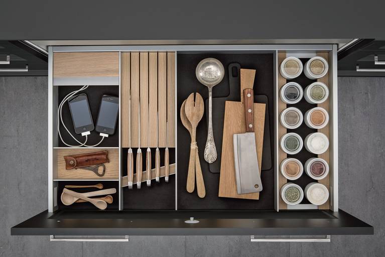 Integrated USB port for iPhones and more, spice jars and knife block in light oak inside SieMatic drawer