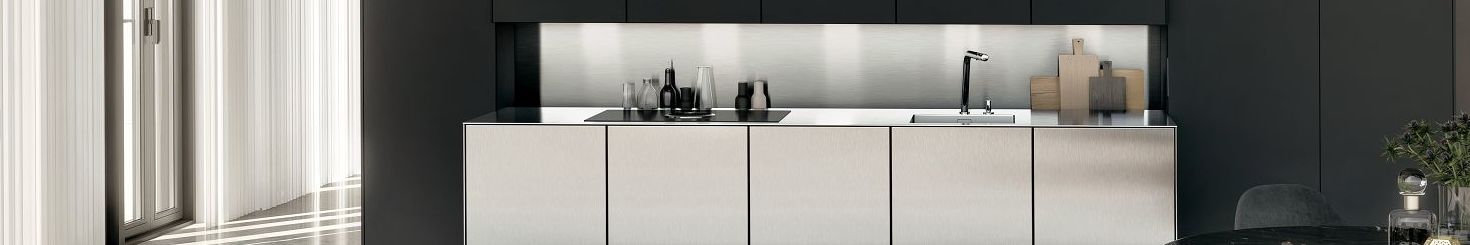 The niche behind this SieMatic stainless steel countertop offers storage space for spices, bottles and cutting boards.